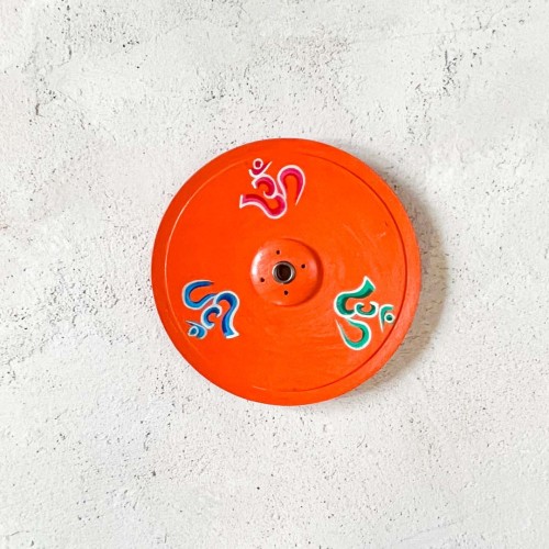 drewniana pomaranczowa podstawka pod kadzidla i kadzidelka w patyczkach z symbolem om