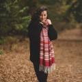 Kobieta otulona szalem kaszmirowym podczas jesiennego spaceru – idealny prezent na chłodne dni