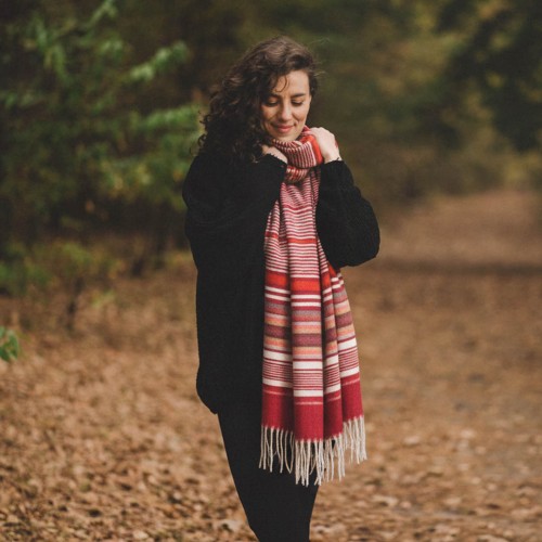 Kobieta otulona szalem kaszmirowym podczas jesiennego spaceru – idealny prezent na chłodne dni