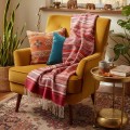 Kolorowy szal kaszmirowy w pasy na musztardowym fotelu – przytulny akcent do wnętrz i pomysł na prezent.