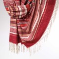 Zbliżenie na miekki szal kaszmirowy z frędzlami w czerwone pasy – ciepły dodatek idealny na jesień