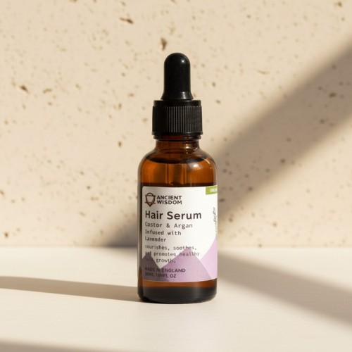 Organiczne serum do włosów z olejem rycynowym i arganowym, z dodatkiem lawendy, w brązowej butelce z pipetą na jasnym tle w naturalnym świetle